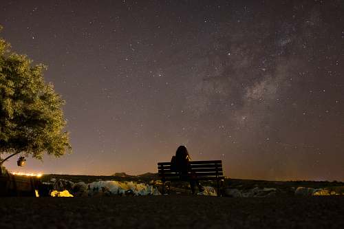 milky way woman sitting on bench along ree space
